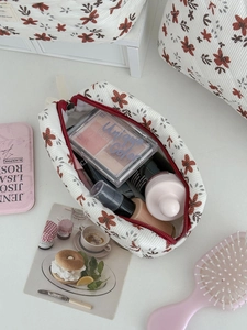 Corduroy floral makeup bag in off-white with orange flowers and organized cosmetics