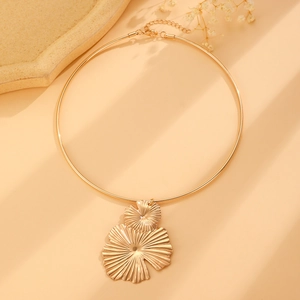 Close-up of golden vintage choker with a large textured petal pendant and adjustable clasp