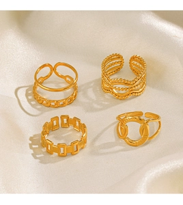 Set of four gold-plated crossover rings featuring geometric textures on soft fabric