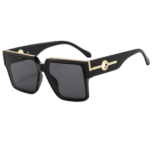 Modern oversized square sunglasses with black frames and gold metal accents on a white background