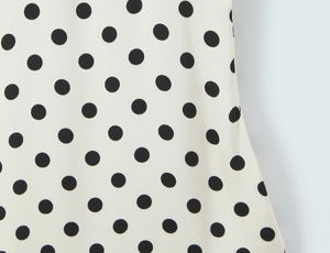 Gros plan du tissu beige avec un motif classique à pois noirs élégants et doux
