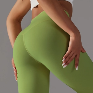 Detail of high-waist yoga leggings in grass green with body-sculpting seam design