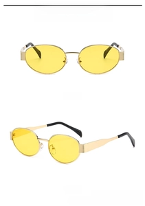Detail view of oval metal sunglasses with golden frames and yellow lenses