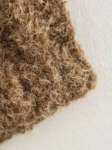 Macro texture view of brown woven wool fabric with raw edge detail and rustic fiber finish