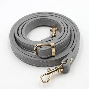 Macro view of grey PU leather bag strap with polished gold-tone metal buckles