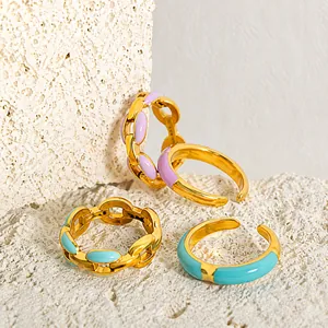 Detail von Goldkettenringen mit bunter helllilafarbener und himmelblauer Emailleglasur