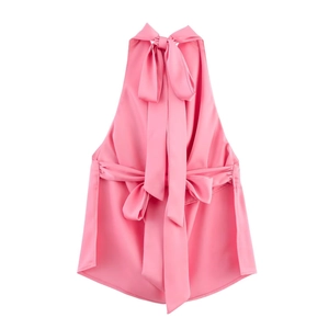 Detail of pink satin halter top featuring a large back bow tie and silky fabric texture