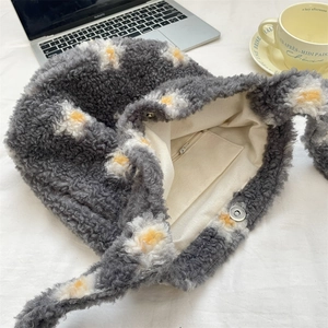 Detail of grey faux shearling tote bag with white floral patterns and magnetic closure