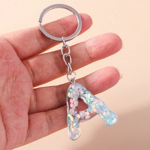 Detail of silver keychain with transparent resin letter A and glitter sequins