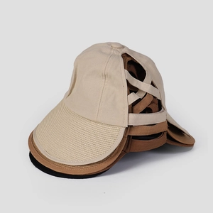Detail of stacked ponytail baseball caps in beige and black with woven brim and crisscross back