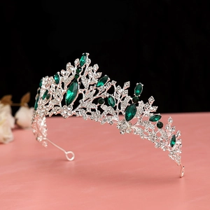Detailed side view of vintage bridal crown with olive green gemstones and silver plating