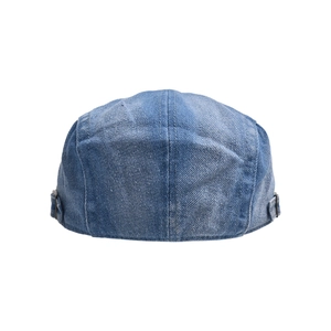 Detail of adjustable metal buckles and stitching on washed blue denim beret cap