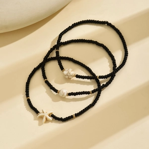 Detail of bohemian starfish charms and turquoise beads on elastic anklet set