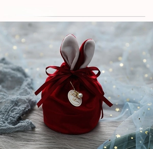 Détail du sac à bonbons de mariage en velours rouge avec oreilles de lapin et perle
