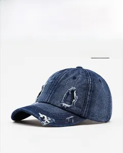 Detailed view of heavy distressed denim baseball cap with navy blue ripped textures