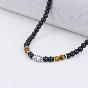 Macro shot of men's beaded necklace with brown tiger eye stones and silver spacers
