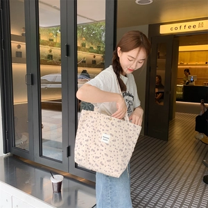 Detail of floral canvas tote bag with purple flower patterns and studio brand label