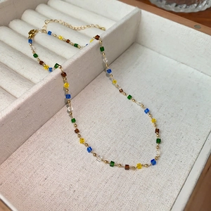 Detail of colorful faceted cube beads necklace with gold spacers and lobster clasp