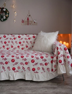 Detail of Christmas sofa cover featuring red candy patterns and festive ruffled edges