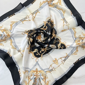 Detail view of silky square scarf with golden baroque chain patterns and elegant pleats