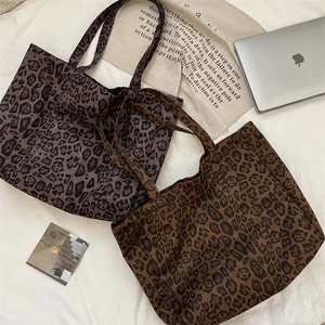 Detail view of large leopard print tote bags in dark brown and cool grey suede finish