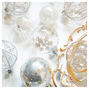 Detailed view of champagne mesh Christmas ornaments with glitter snowflakes on marble