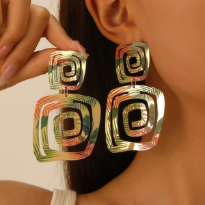 Gros plan de boucles d'oreilles carrées avec motif de feuilles tropicales sur modèle