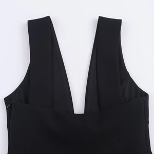 Detail eines schwarzen ärmellosen Kleides mit tiefem V-Ausschnitt und symmetrischen Trägern