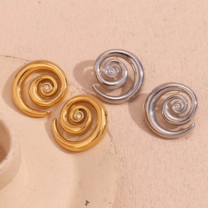 Detailed view of gold and silver spiral earrings with single centered cubic zirconia