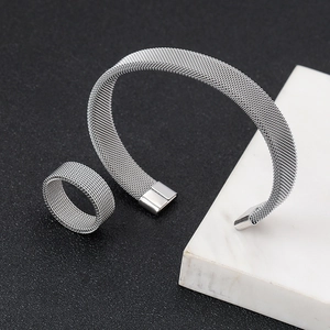 Minimalist silver mesh woven stainless steel bracelet and ring set on marble