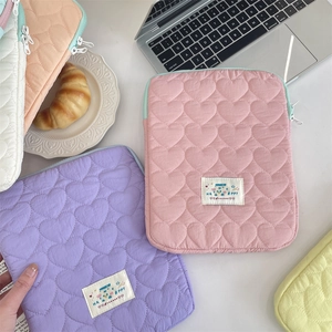 Detail of heart-quilted fabric laptop sleeve with shockproof padding and zipper closure