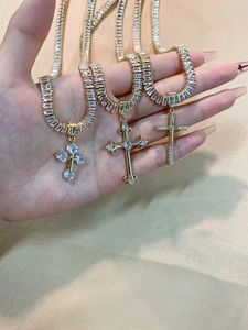 Detailed macro view of three golden cross necklaces with zircons on champagne silk