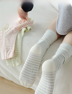 Detailed texture of macaron-colored striped knit socks in a soft home setting