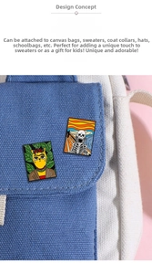 Artistic enamel pins featuring Frida cat and The Scream skeleton on a blue canvas bag
