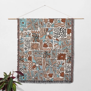 Detail of bohemian sun and daisy woven tapestry with colorful tassel edges and wood bar