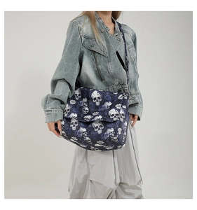 Detail of nylon tote bag featuring blue roses and skull print with a wide shoulder strap