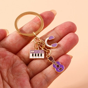 Detail of gold metal keychain with purple enamel piano, guitar, and headphone charms