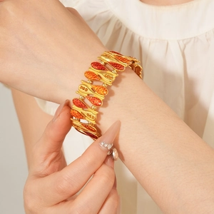 Close-up of a vintage golden bangle with water-drop enamel and elegant zircon accents