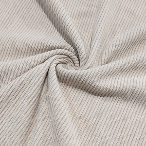 Close-up of beige corduroy fabric texture showing soft vertical ribs and material drape