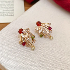 Close-up of gold-plated fireworks earrings with floral mop and colorful gemstone tassels