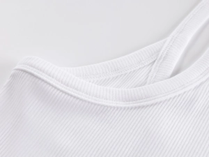 Detail of white ribbed knit fabric and deep V-neck stitching on a slim-fit tank top