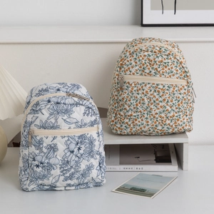 Detailed view of two small quilted floral backpacks with elegant diamond stitching patterns