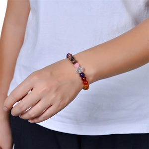 Natural crystal beaded yoga bracelet with silver lotus charm worn on a female wrist