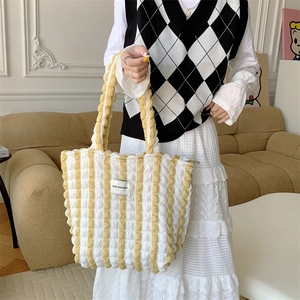 Close-up of yellow and white striped bubble texture fabric on a stylish tote bag