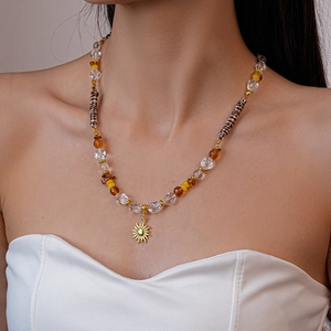 Détail du collier de perles bohème avec pendentif soleil doré sur un mannequin femme