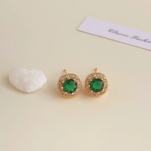 Detail of 18K gold plated earrings featuring green zircon and micro-paved white crystals