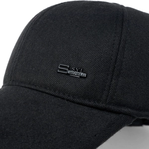 Detailed macro view of black winter baseball cap fabric and premium metal brand logo
