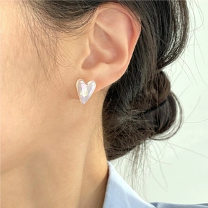 Close-up of irregular heart pearl earrings on model with iridescent white finish