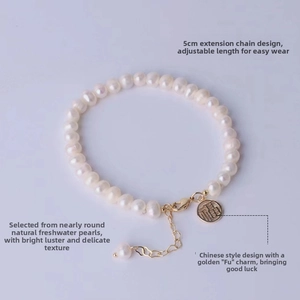 Detailed macro shot of natural pearl bracelet with gold Fu charm and extension chain