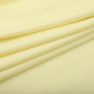 Detaillierte Nahaufnahme von cremefarbenem Strickstoff mit elegantem Faltenwurf für Kleider